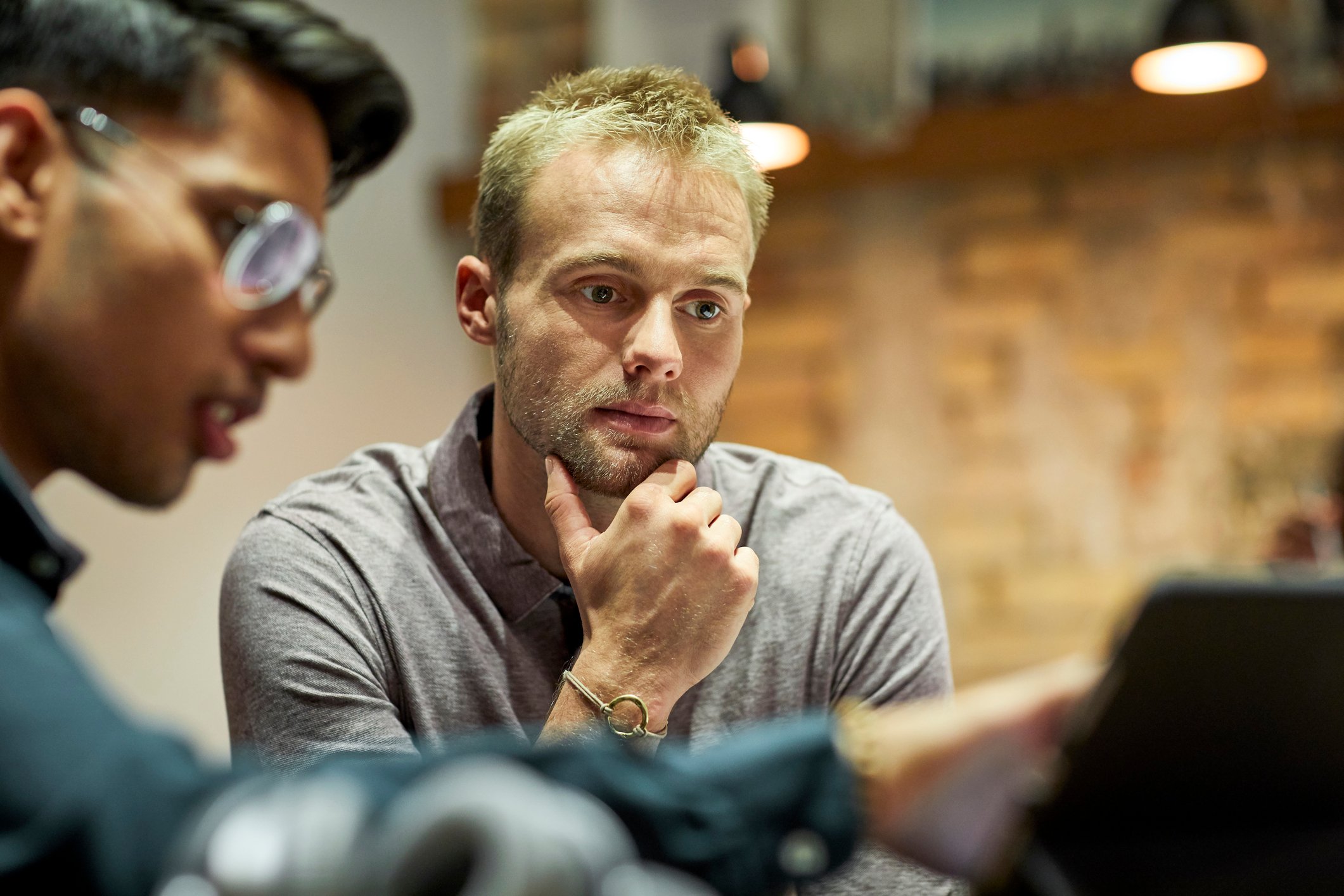 A man explaining something to his coworker. 