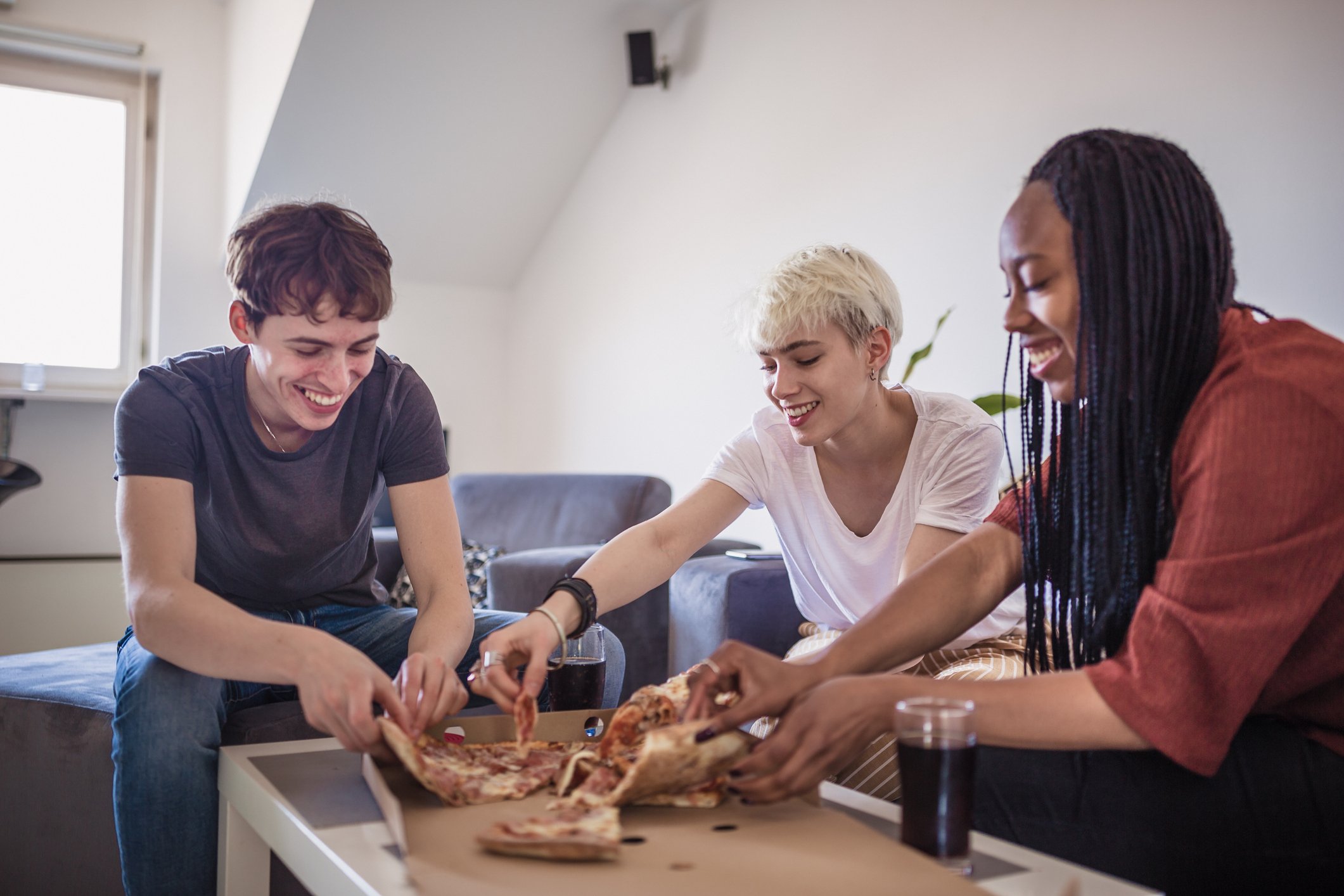 Three people share a pizza.