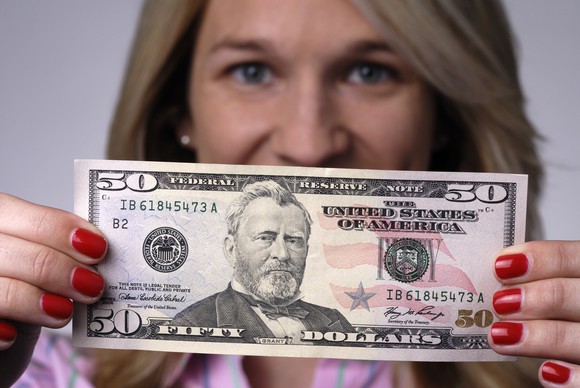 A person holding a $50 bill.