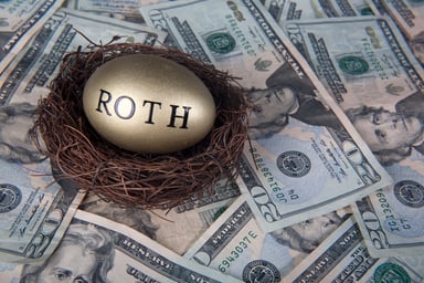Gold Roth nest egg sitting on twenty dollar bills. 