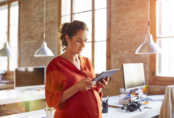 An investor looks at something on her tablet in an office.