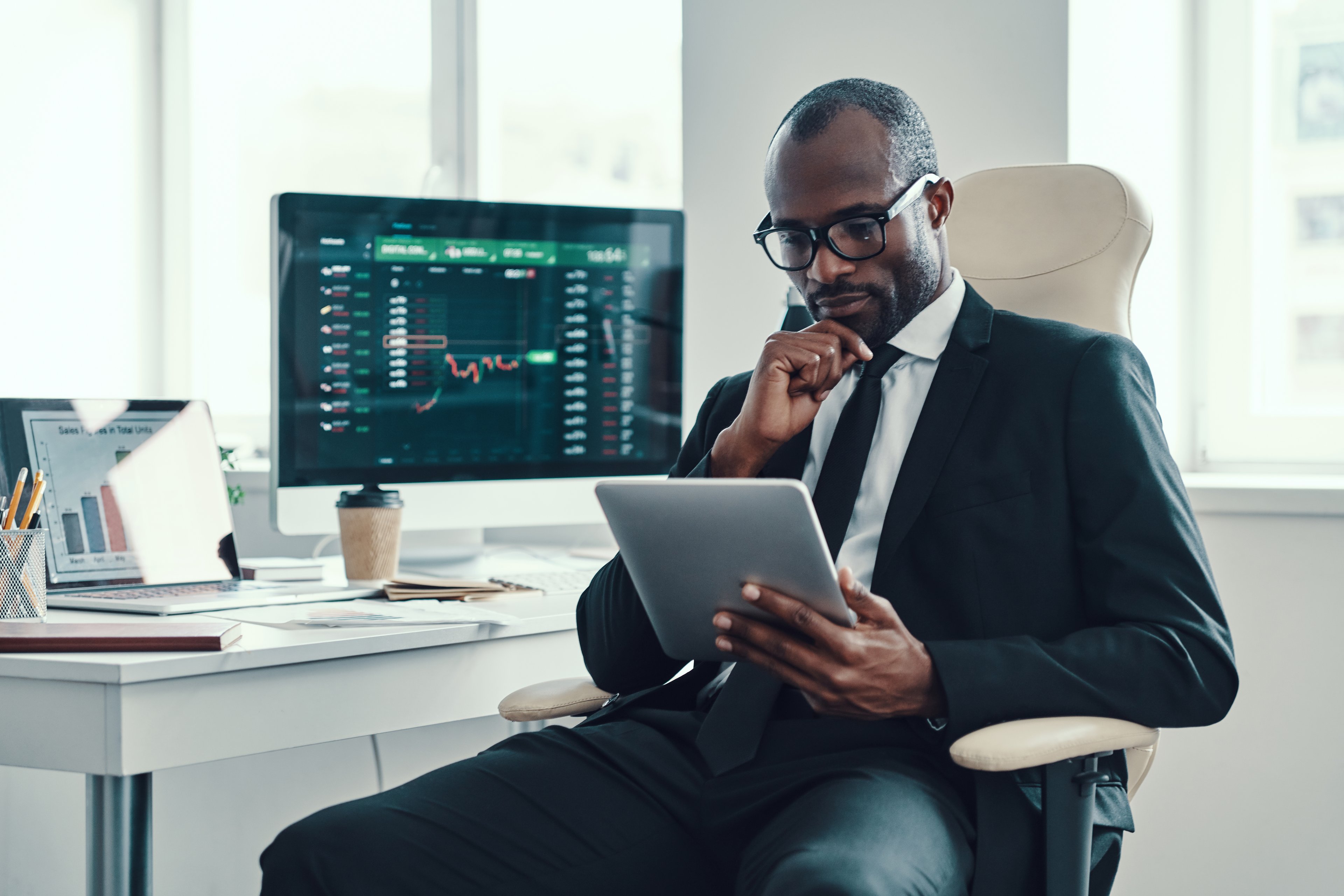Person in suit looking at financial charts.