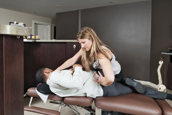 Chiropractor performing adjustment on patient.