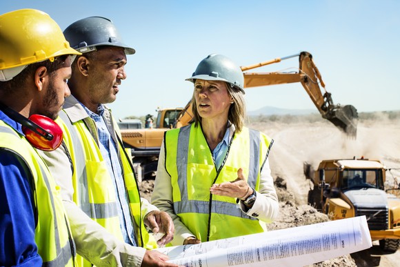 Workers discuss plans at a quarry.