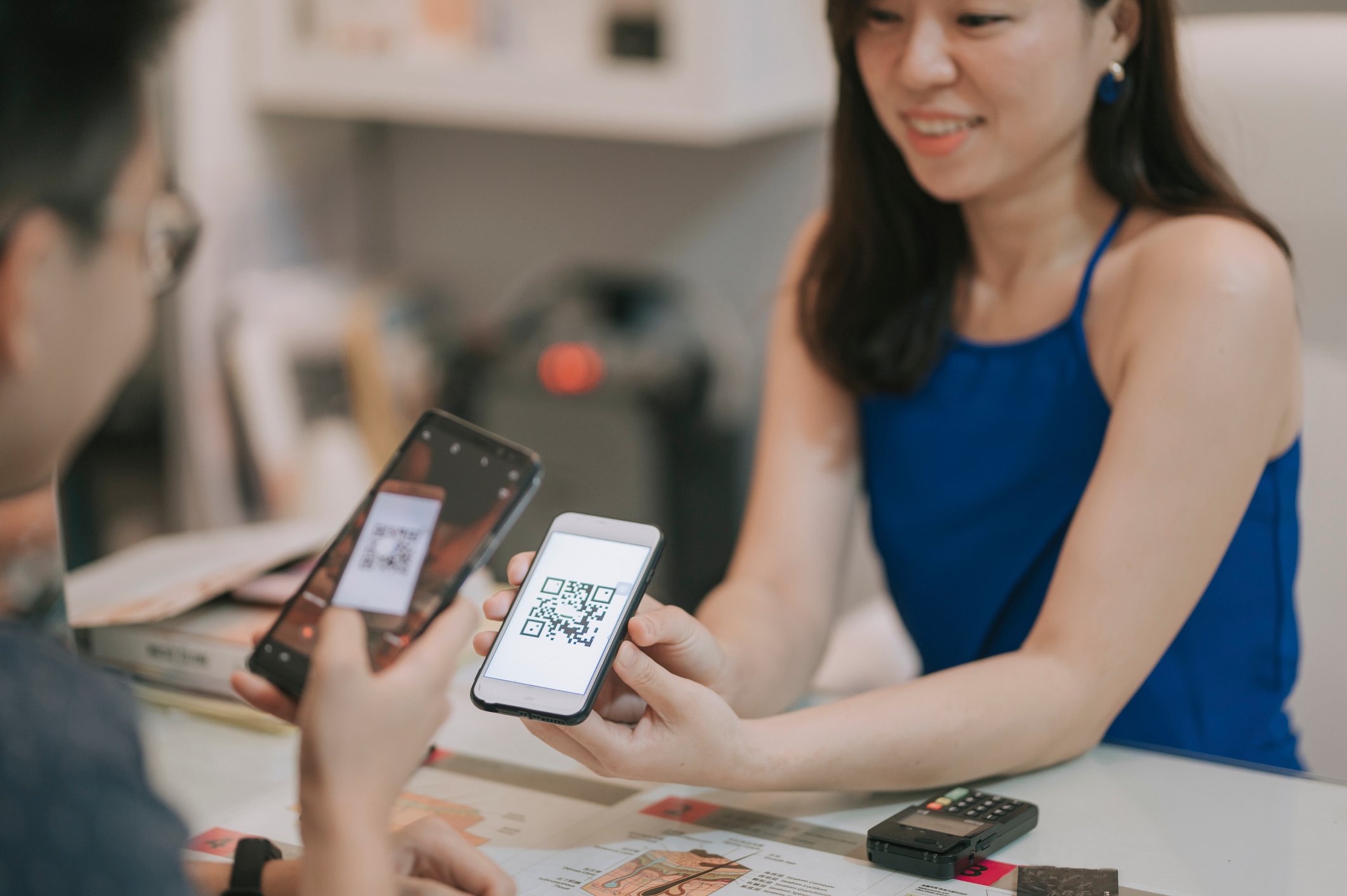 A person receiving payment via QR code on a cell phone.