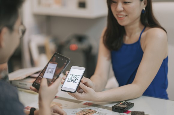 A person receiving payment via QR code on a cell phone.