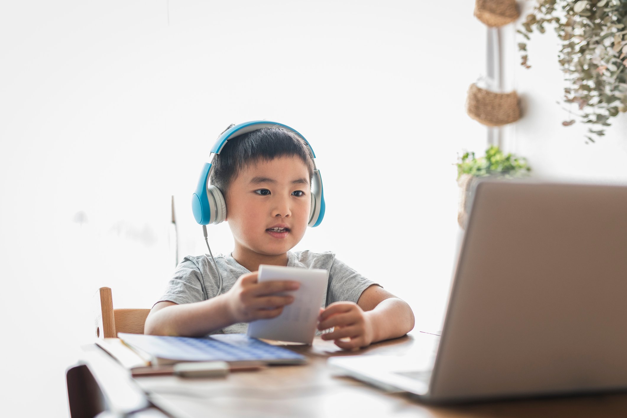 Youth wearing headphones sitting in front of laptop