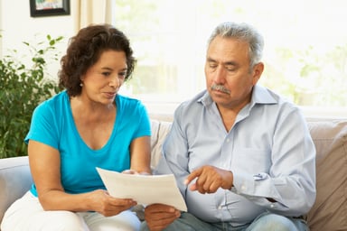 Senior couple pointing at document