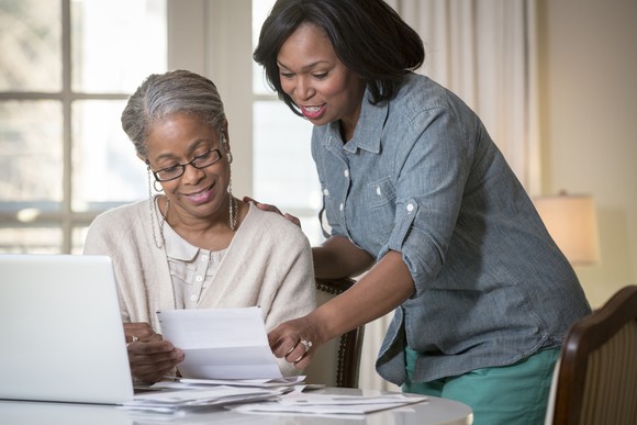 Two people reviewing a paper document.