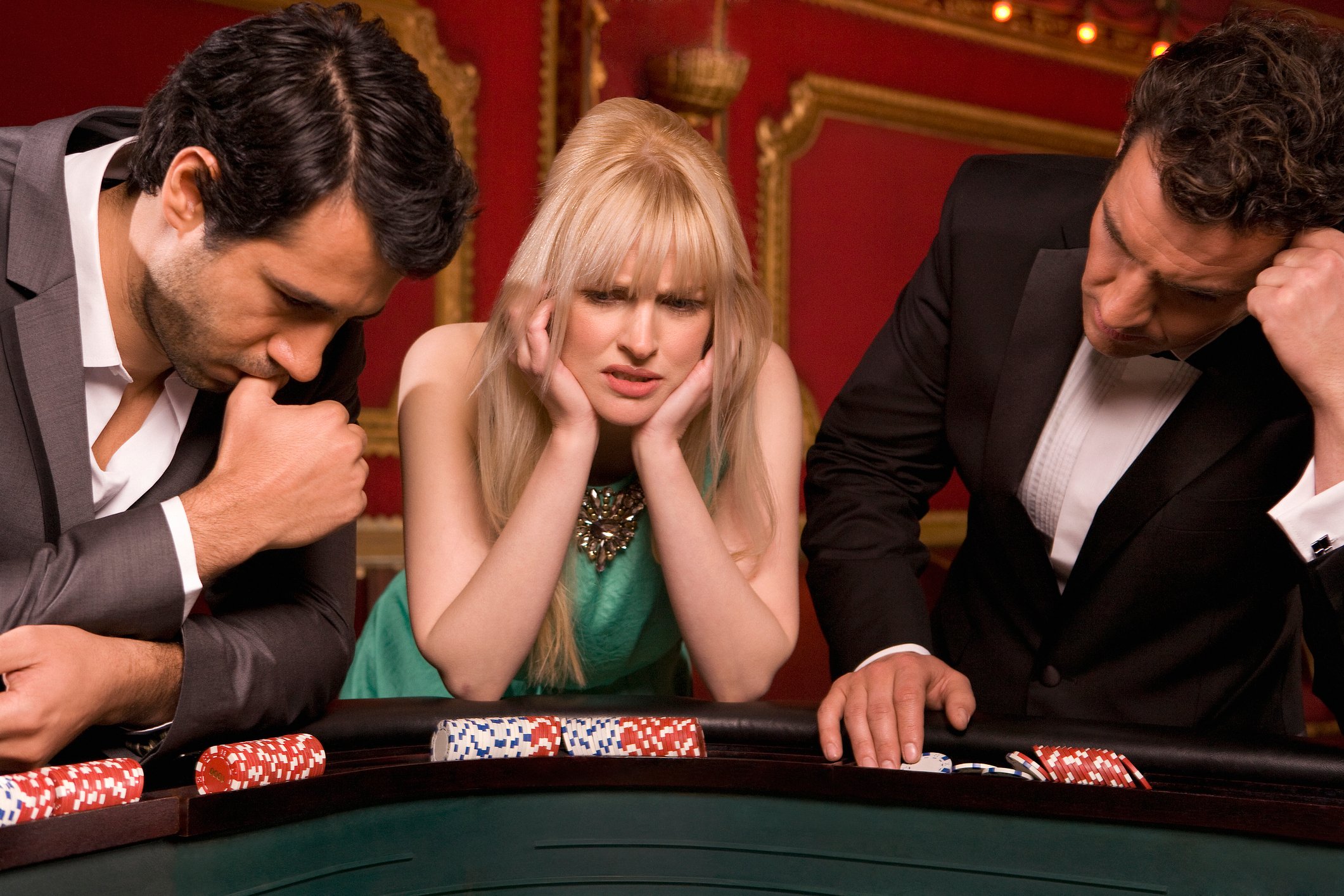 Three unhappy gamblers standing at a craps table.