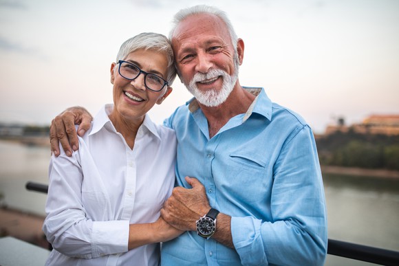 A senior man and woman holding hands.