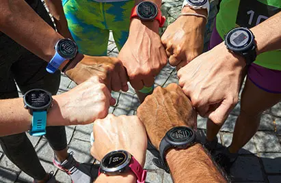 Seven hands in a circle showing Garmin watches. 