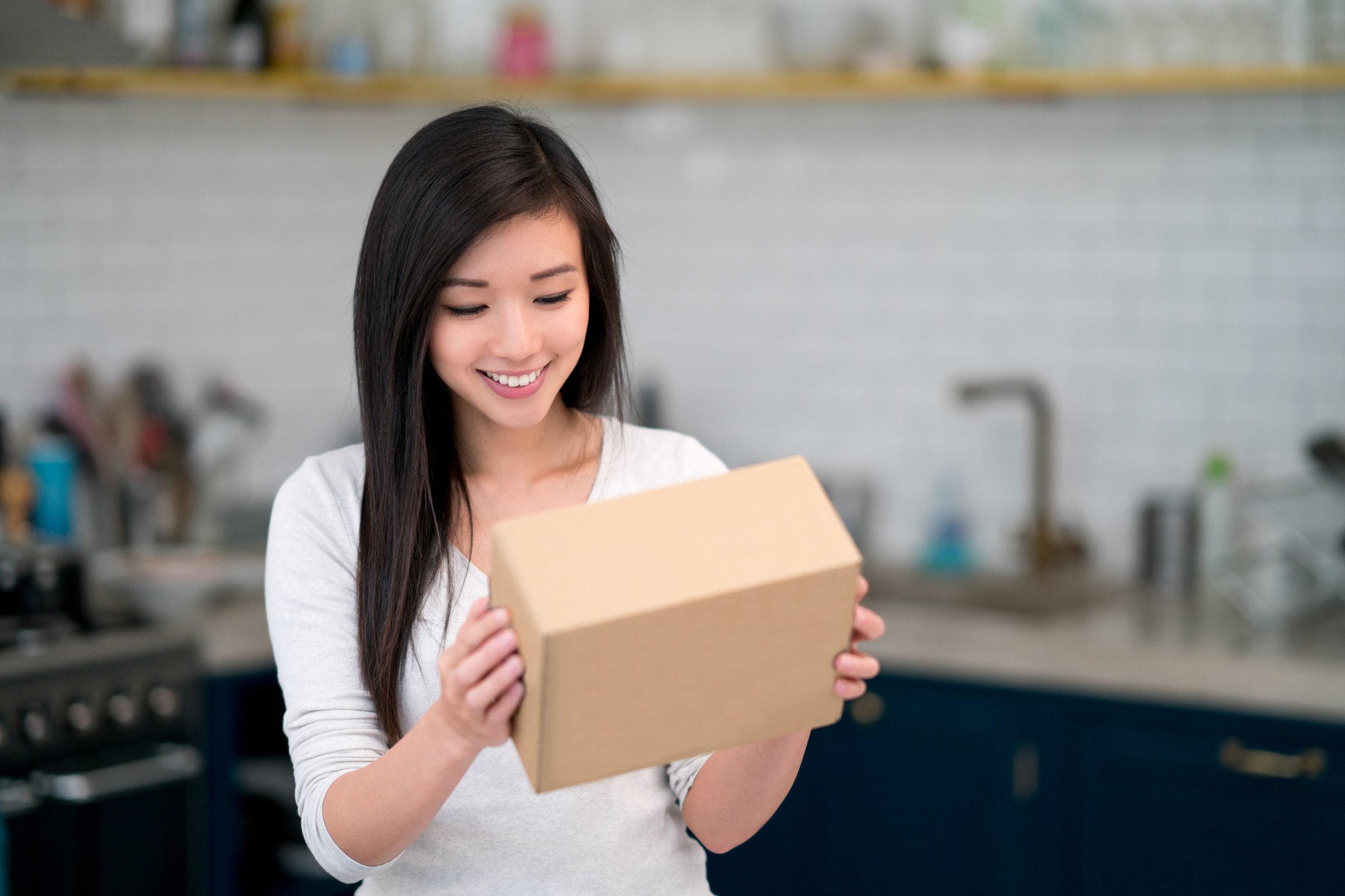 A woman holding a small, brown box.