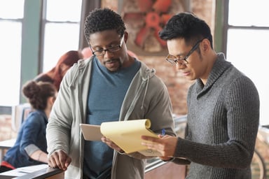 two coworkers compare business figures