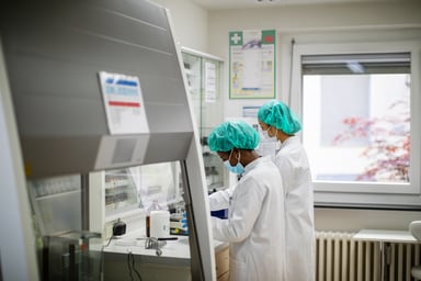 two scientists stand while working in a lab
