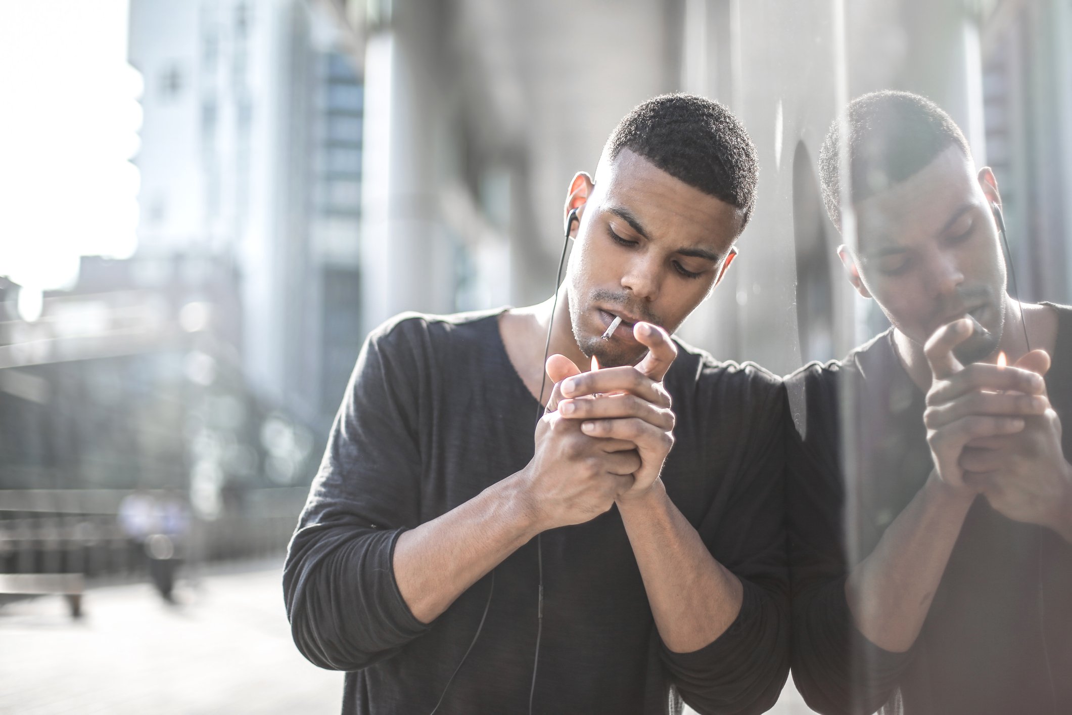 Young person lighting a cigarette.