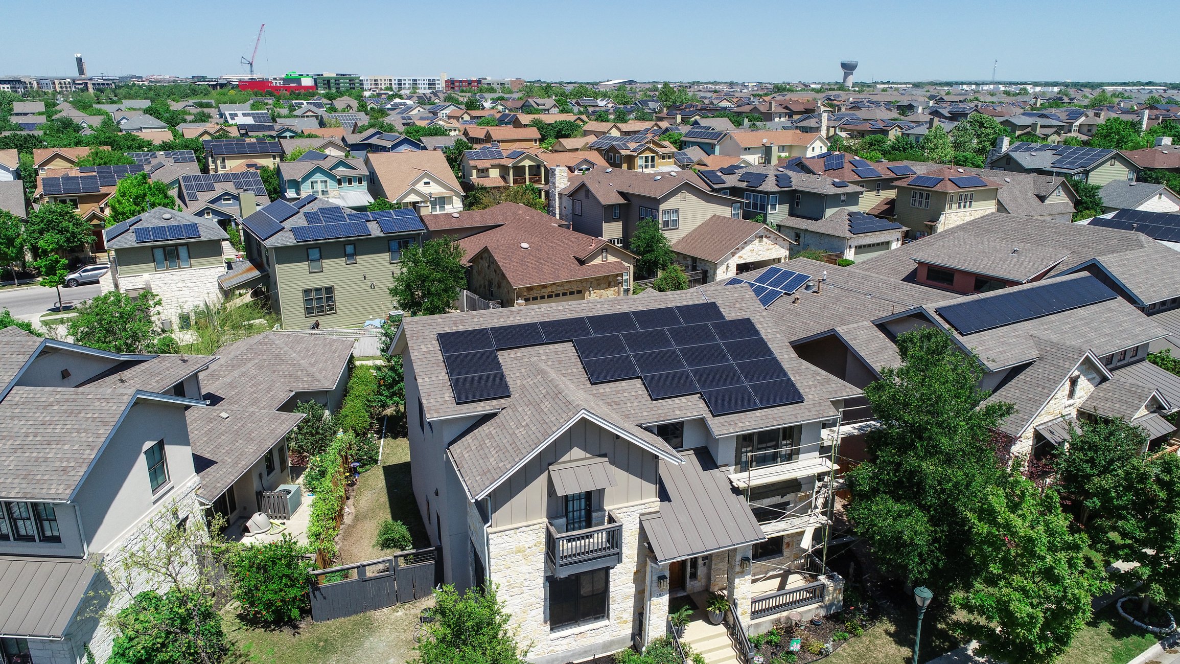Aerial view of homes with solar panels on roofs. 