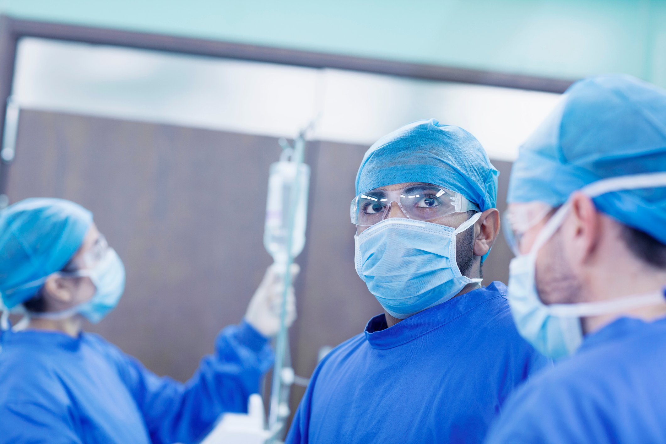 A surgeon and their staff prepare to perform a procedure on a patient.