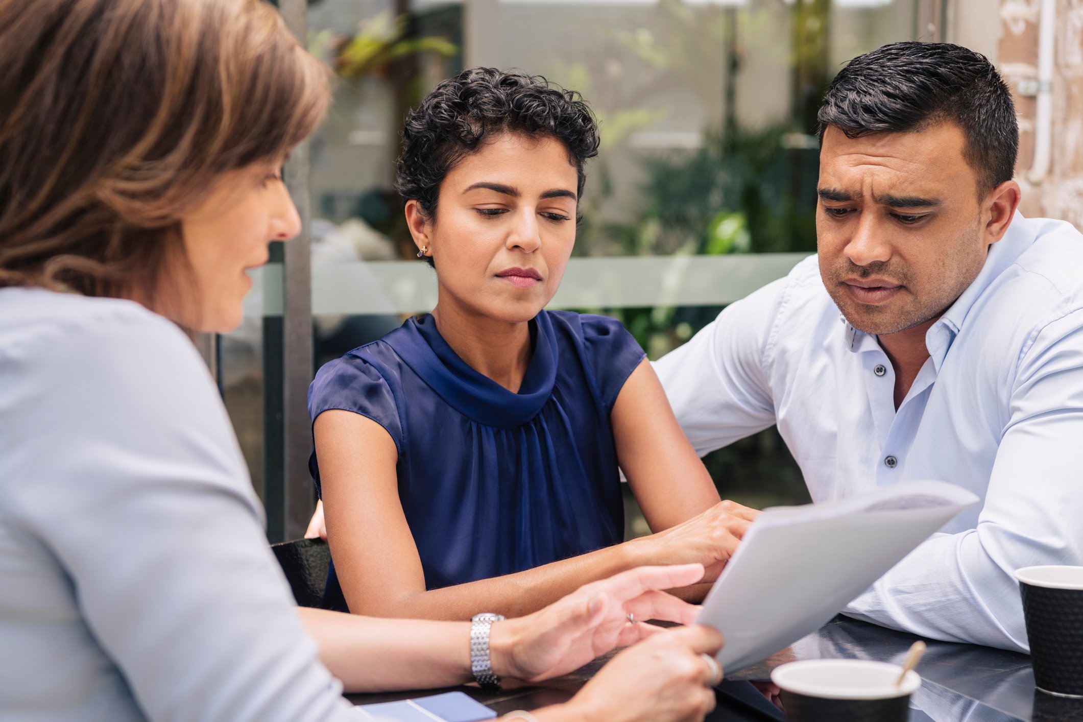 Three people look at a document.