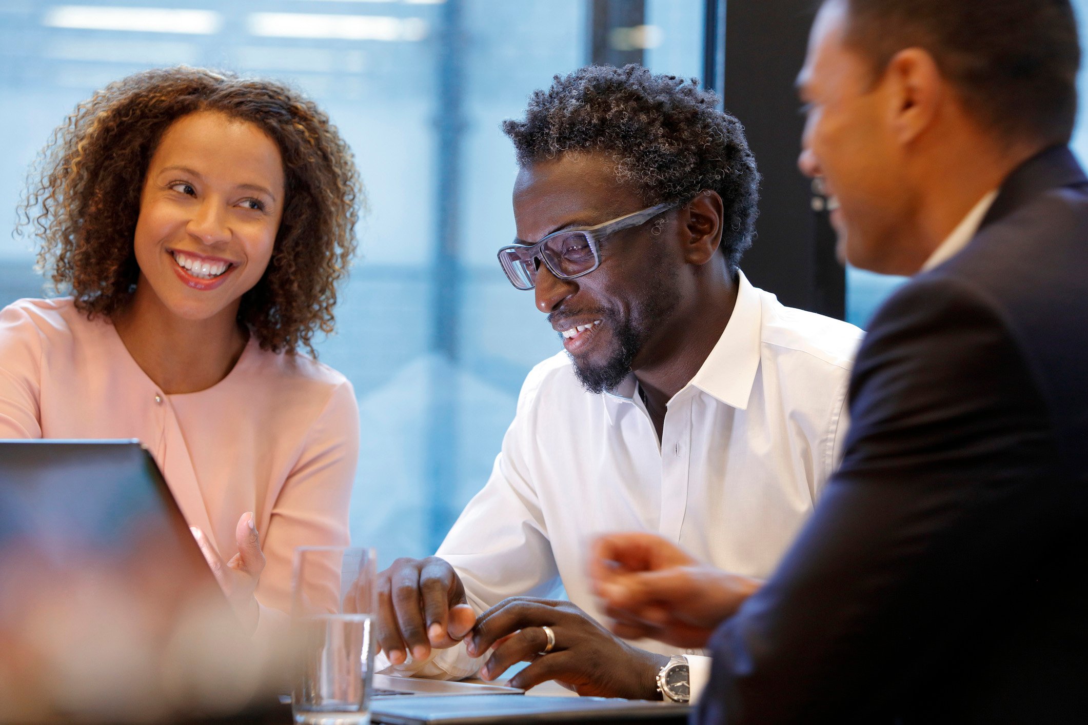Two smiling people meeting with a financial advisor. 