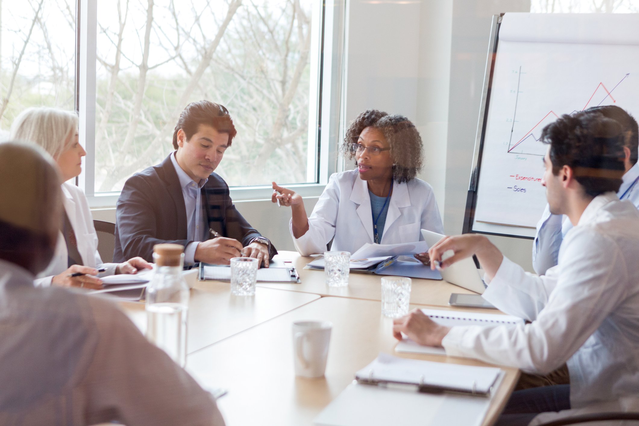 A doctor presents to coworkers at a meeting.