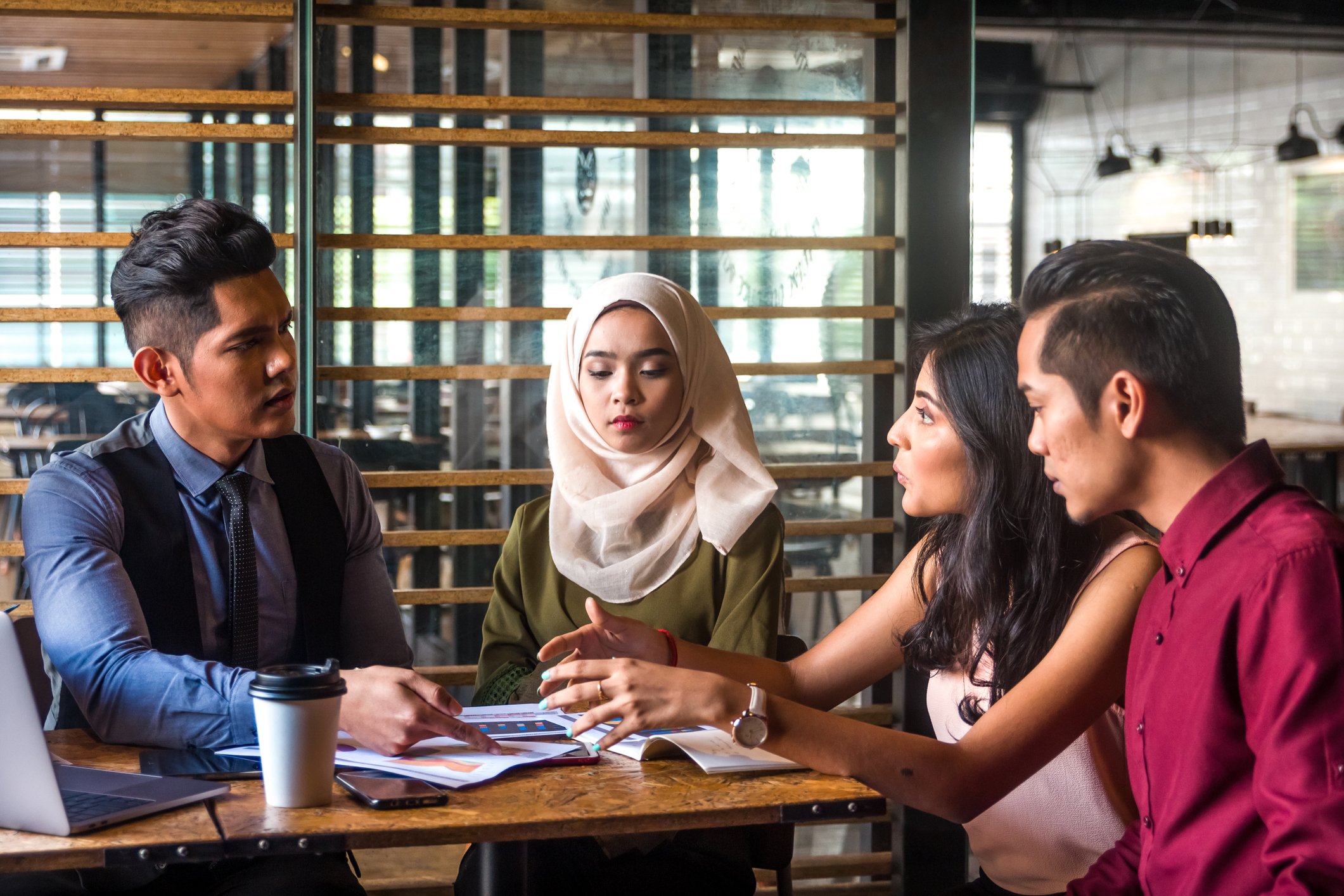 People sitting at a table looking at documents. 
