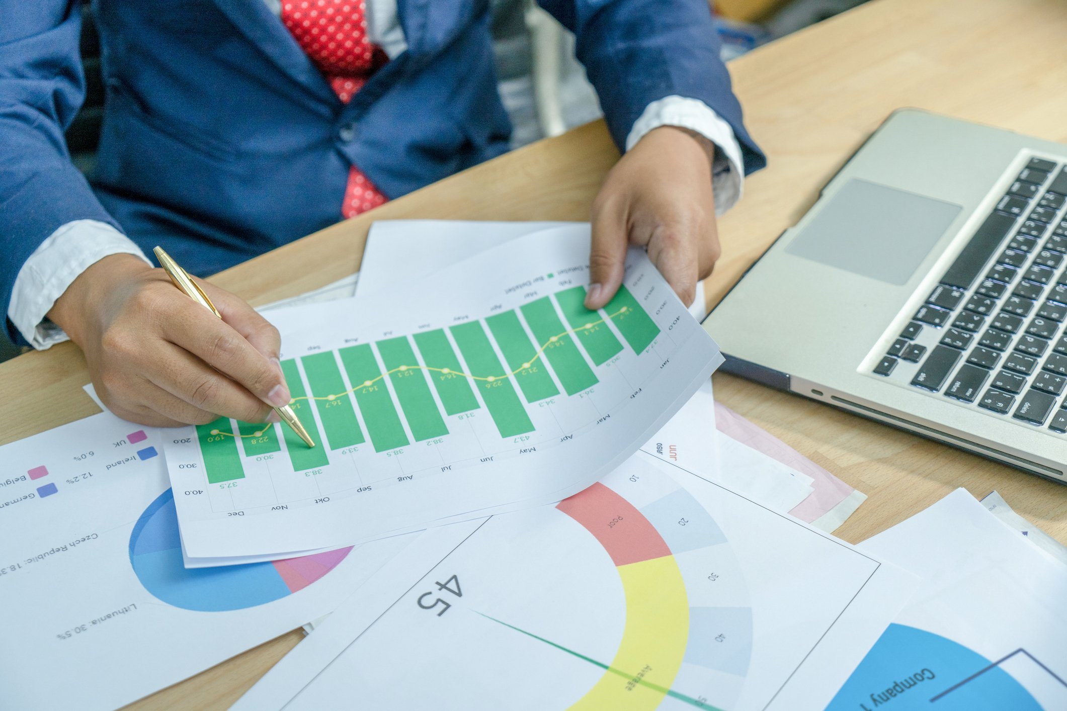 Papers with charts and graphs on a desk.