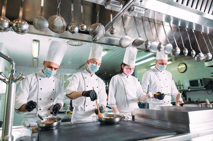 Hospitality workers in a kitchen.