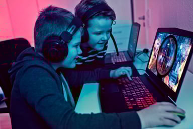 Boys Wearing Headphones Playing Game on Laptop