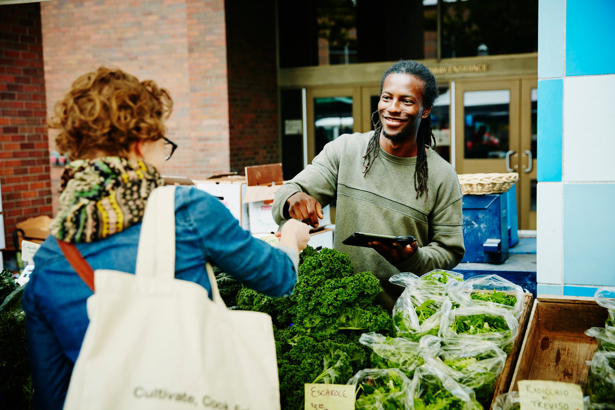 A farmer takes a credit card payment at a market.