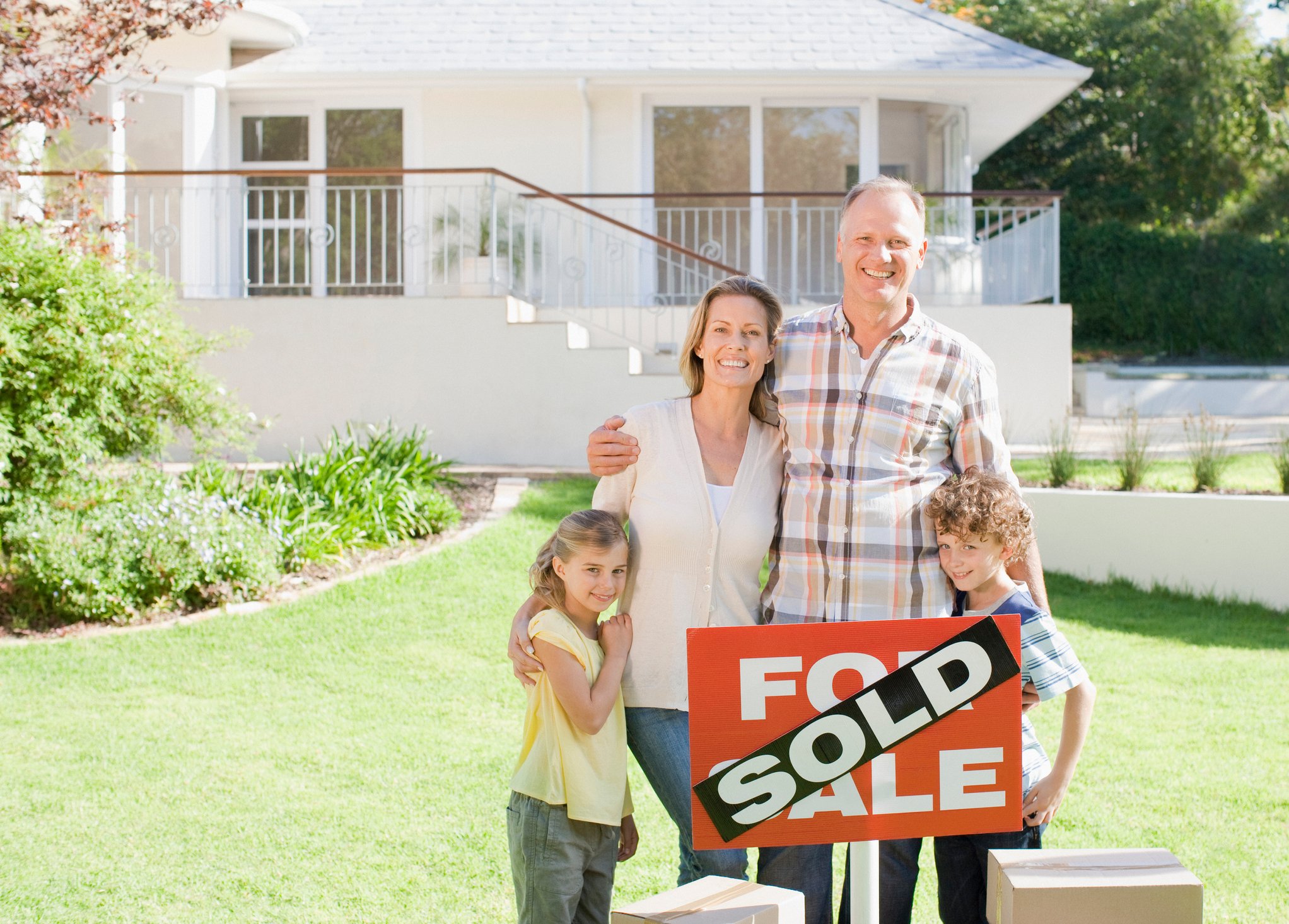Family standing in front of a sold home.