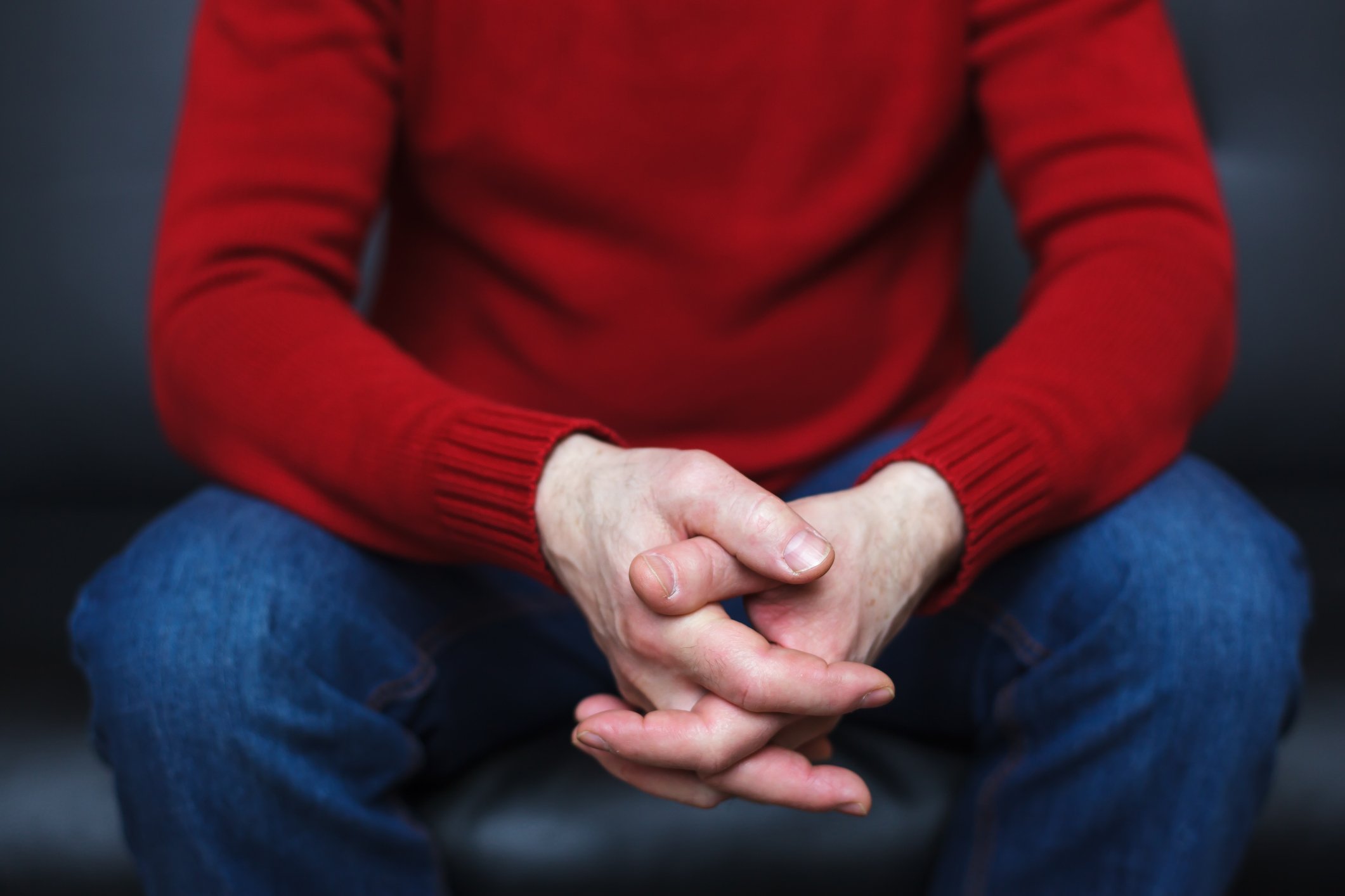 A person sitting with their fingers crossed.