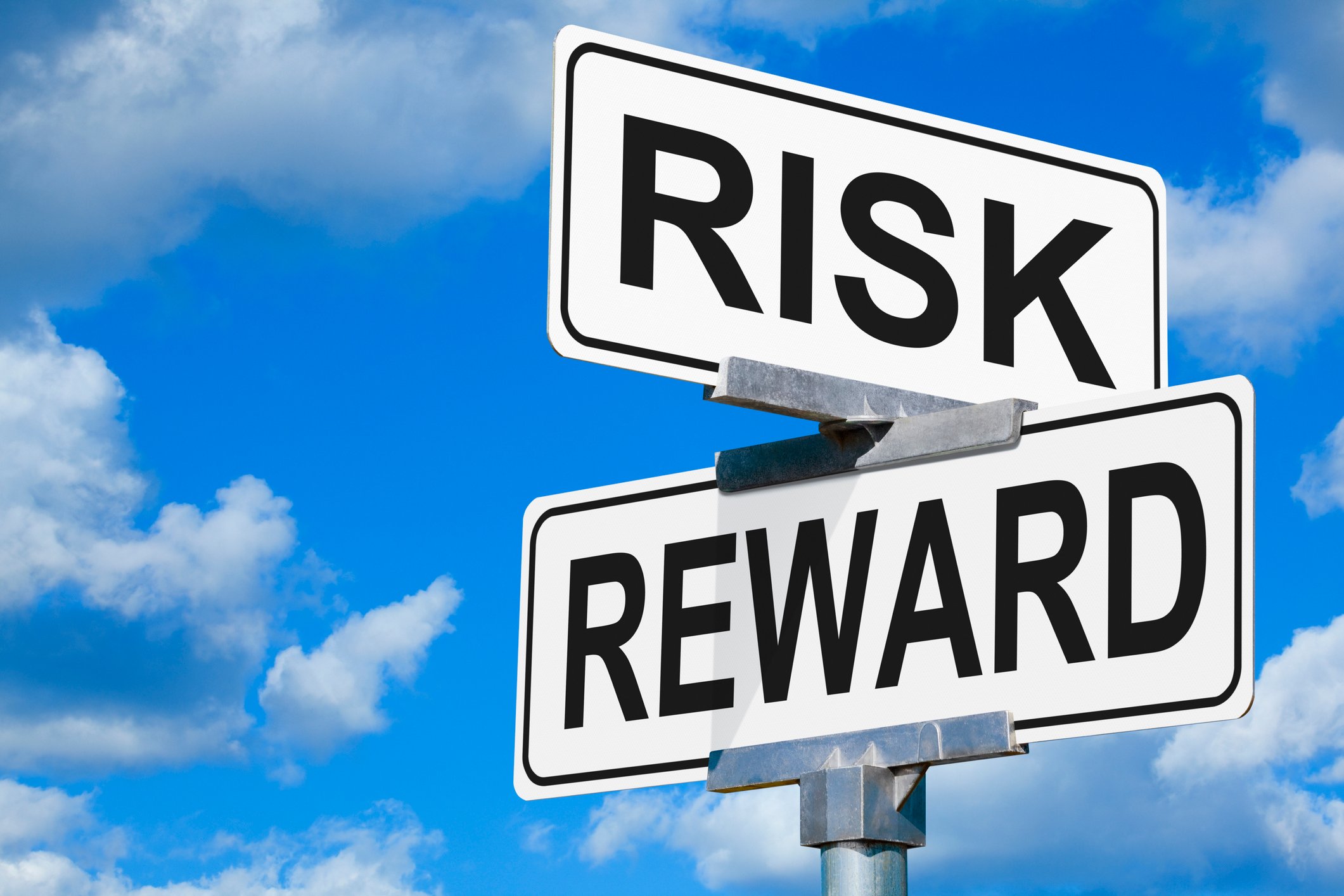 Two signs stacked on top of each other that say risk and reward. 