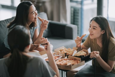 group of friends eating pizza