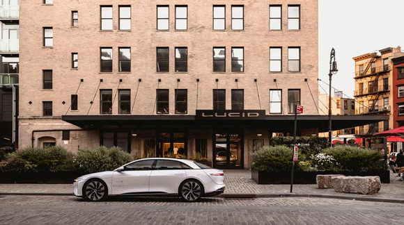 Lucie Motors New York City showroom with Lucid Air sedan parked in front.