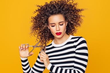 getty-young-woman-trims-curly-hair