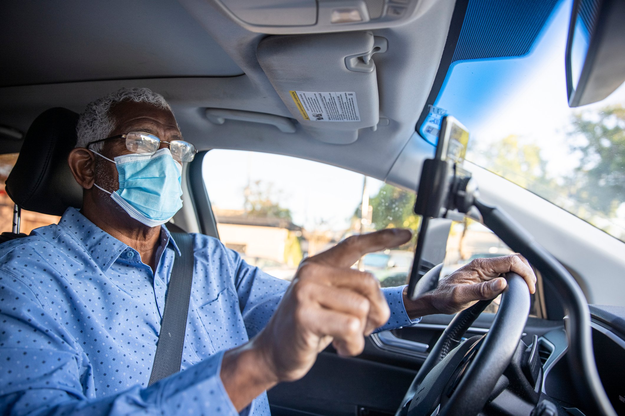 Man setting up navigation in car.