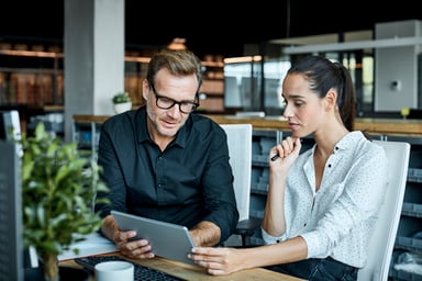 Two collegues confering looking at a tablet