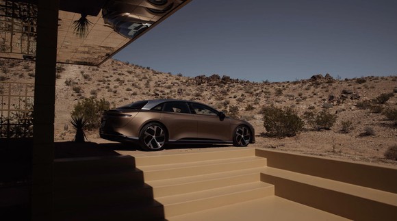 A Lucid Air parked in the driveway of a desert home.