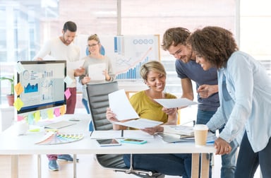 People at a desk looking at reports.