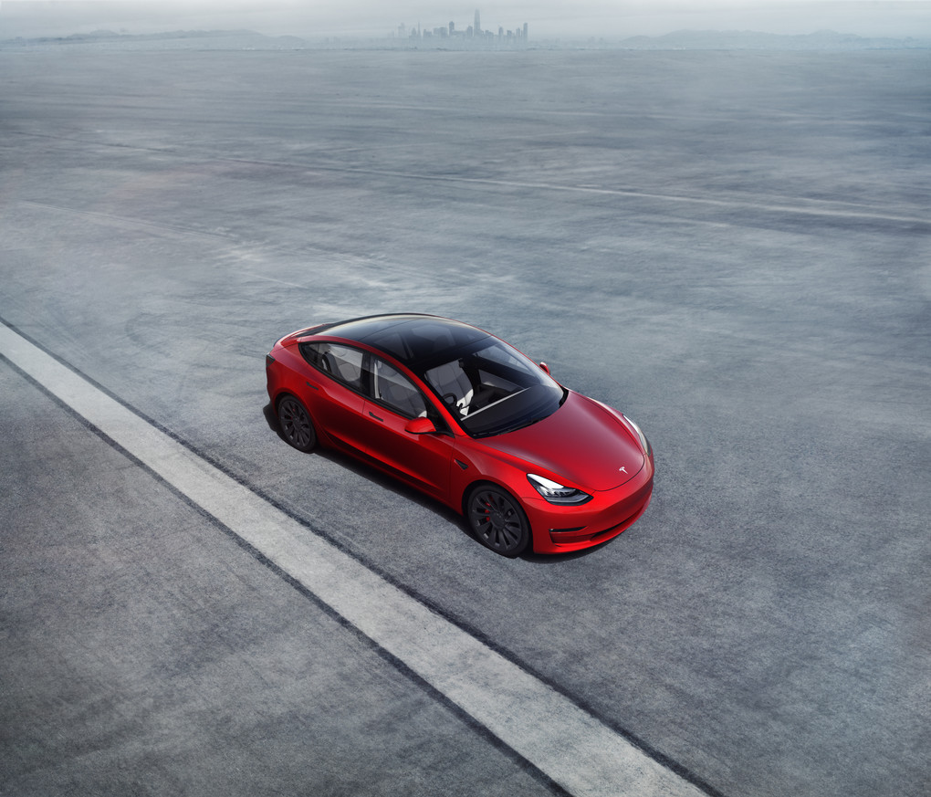 red Tesla Model 3 on track.