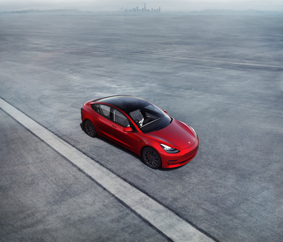 red Tesla Model 3 on track.