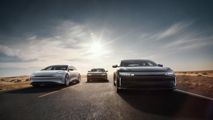 Three Lucid Air vehicles driving on a road.