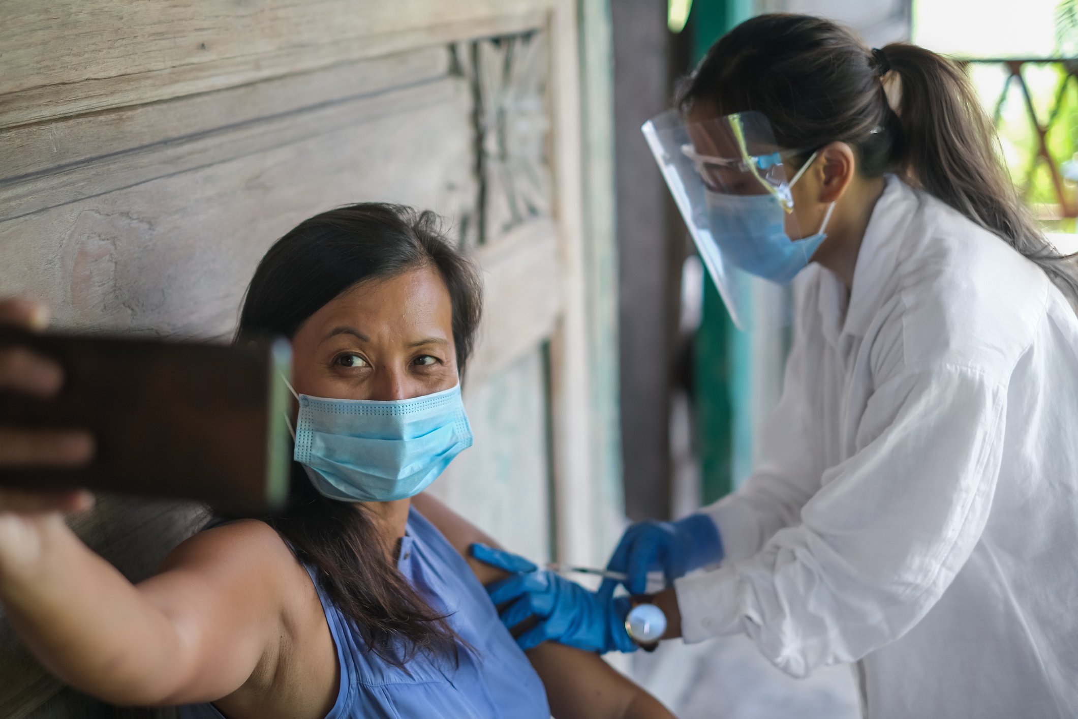 Patient takes selfie while receiving injection.