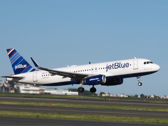 A JetBlue Airways plane preparing to land on a runway.