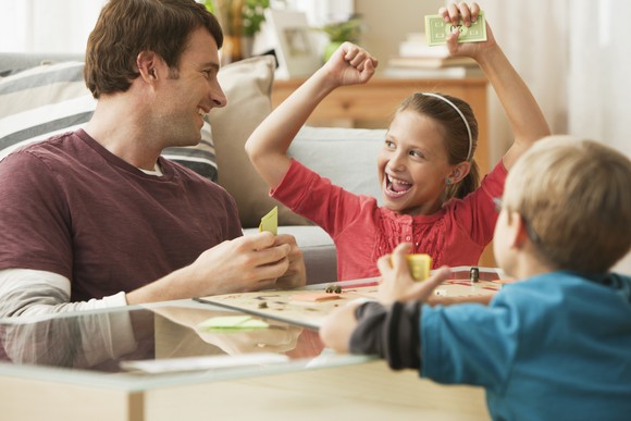 A parent playing a board game with children.