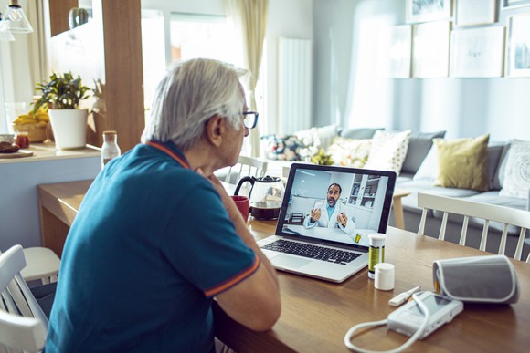 Elderly patient consulting with a doctor online.