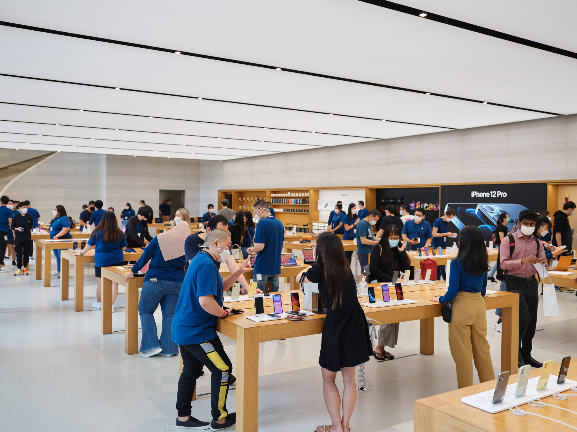 Customers browsing inside an Apple retail store.