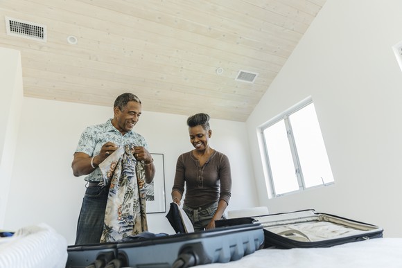 A man and woman unpacking a luggage.