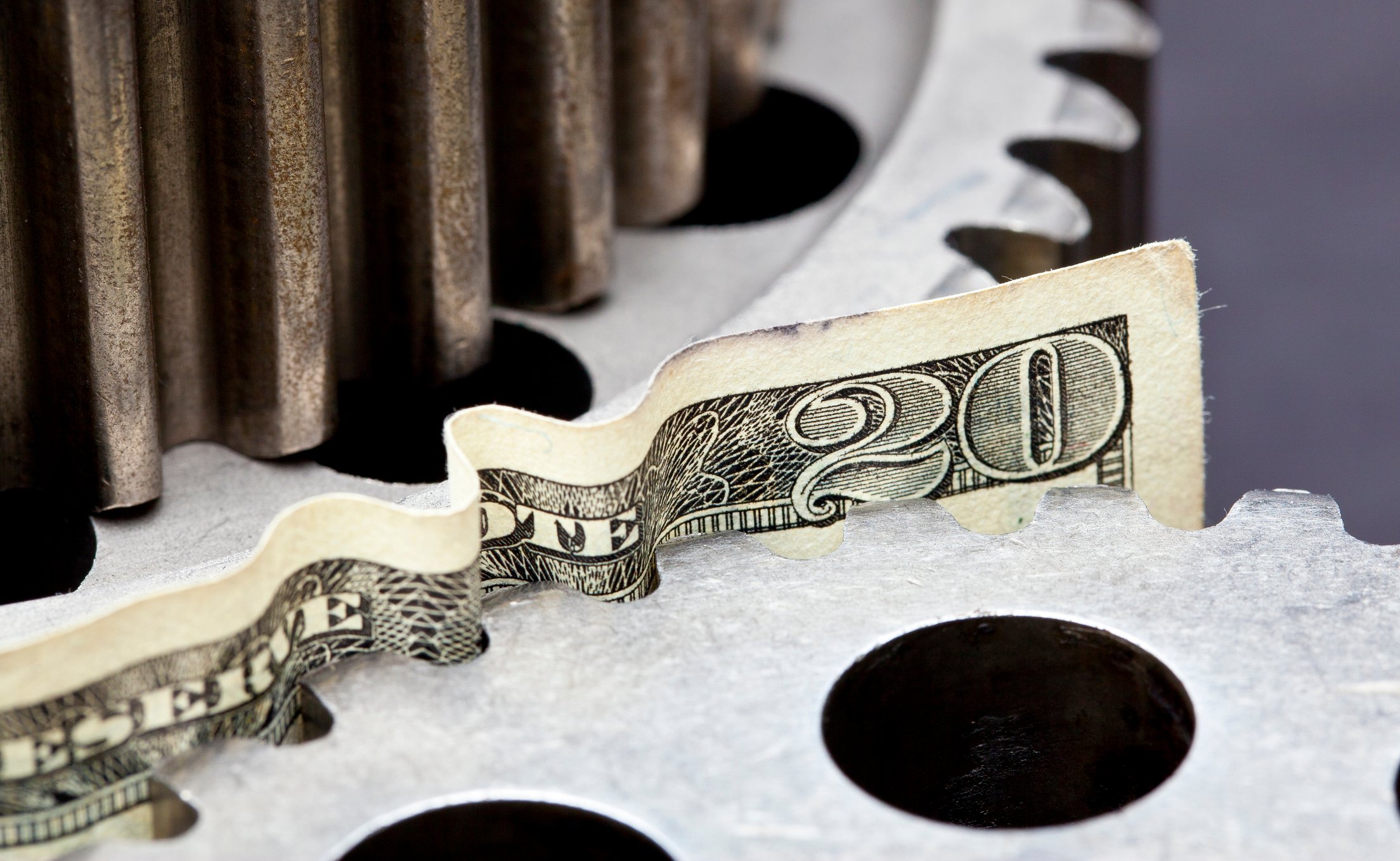 A $20 bill stuck between two gears.